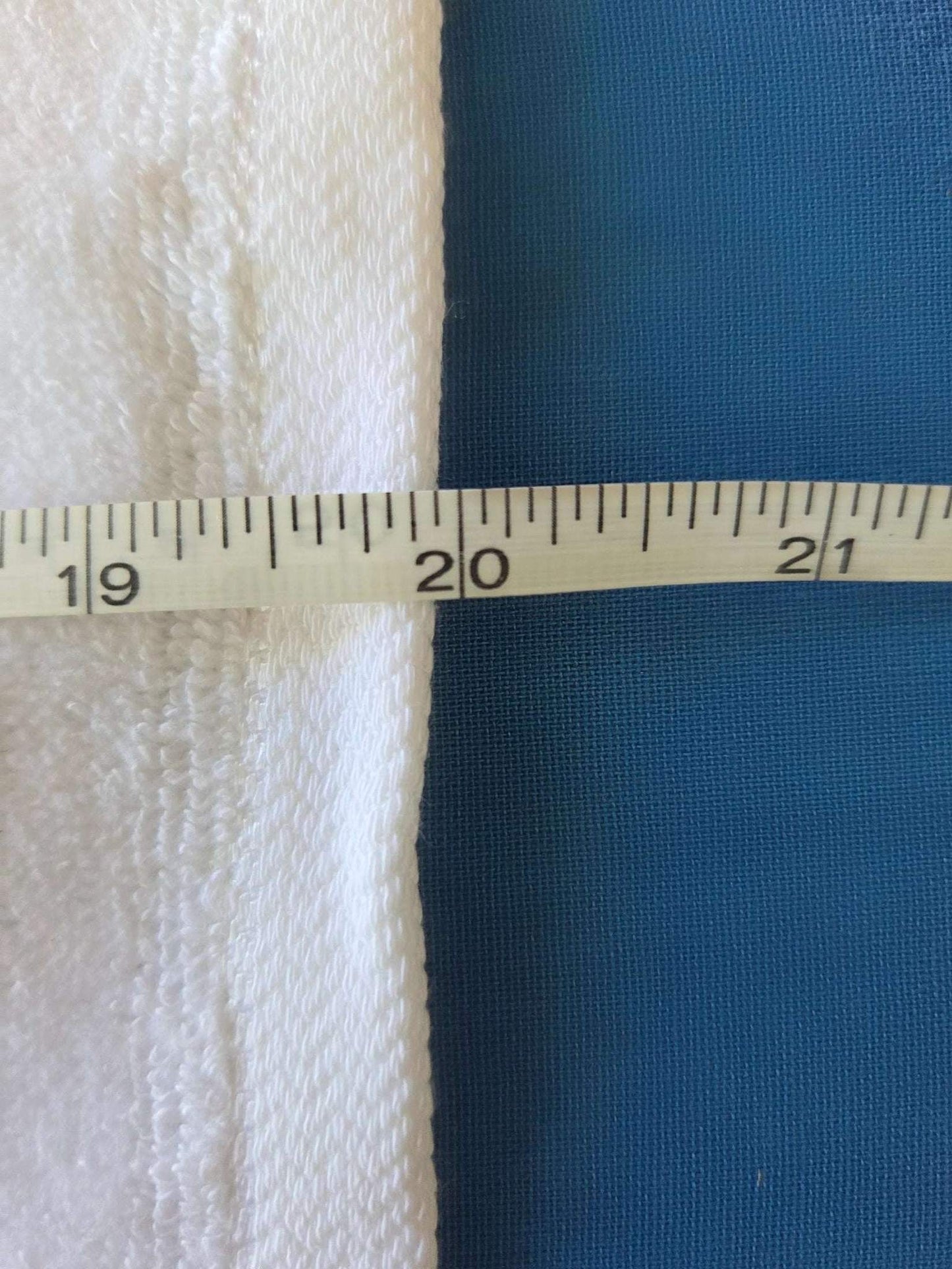 Blue fabric with a ruler showing measurements on a white background