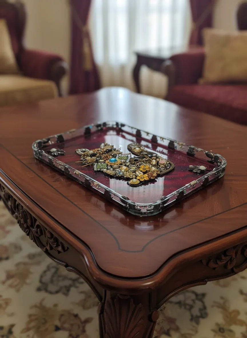Upcycled vintage jewelry cat resin tray on deep red background, with brooches, pearls and watch parts