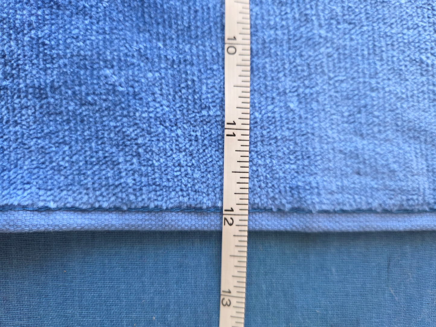 Roll of blue fabric with a measuring tape indicating dimensions