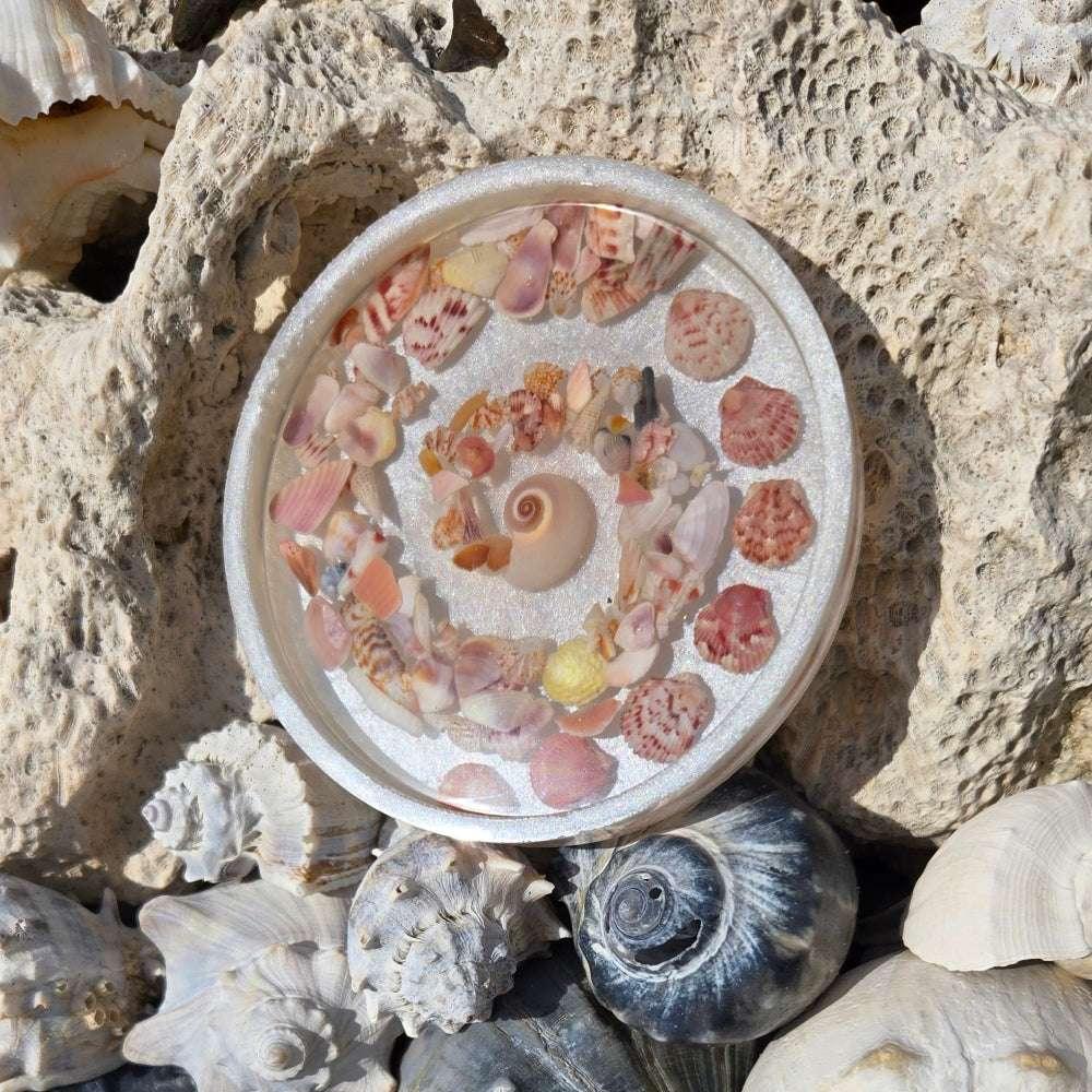 Resin coaster with spiral shell centerpiece, beach-inspired décor