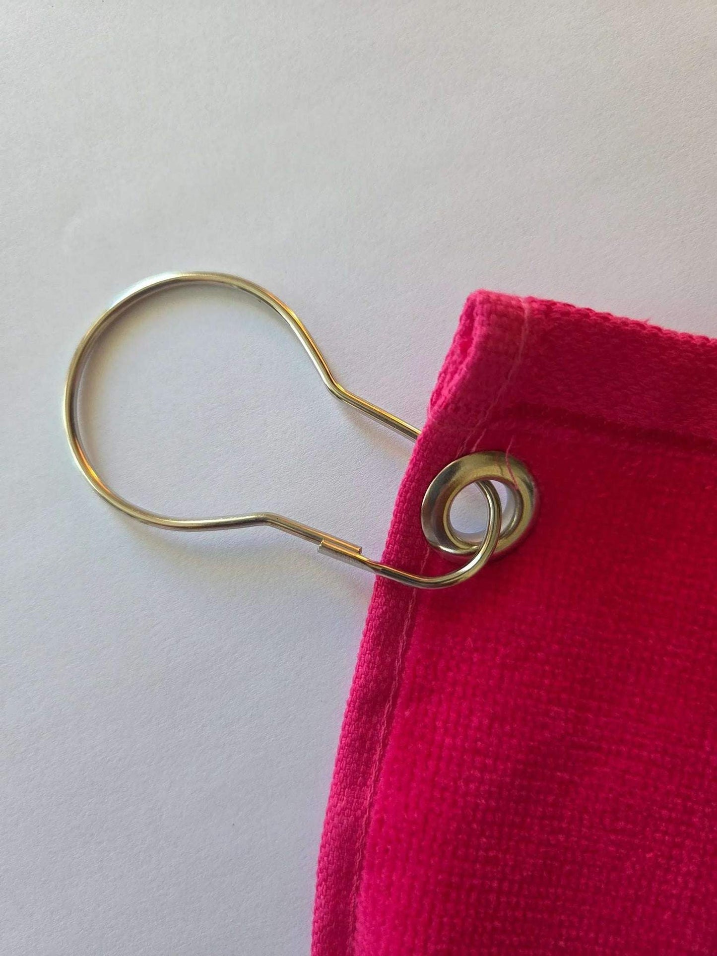 corner brass grommet with silver clip ring on hot pink towel