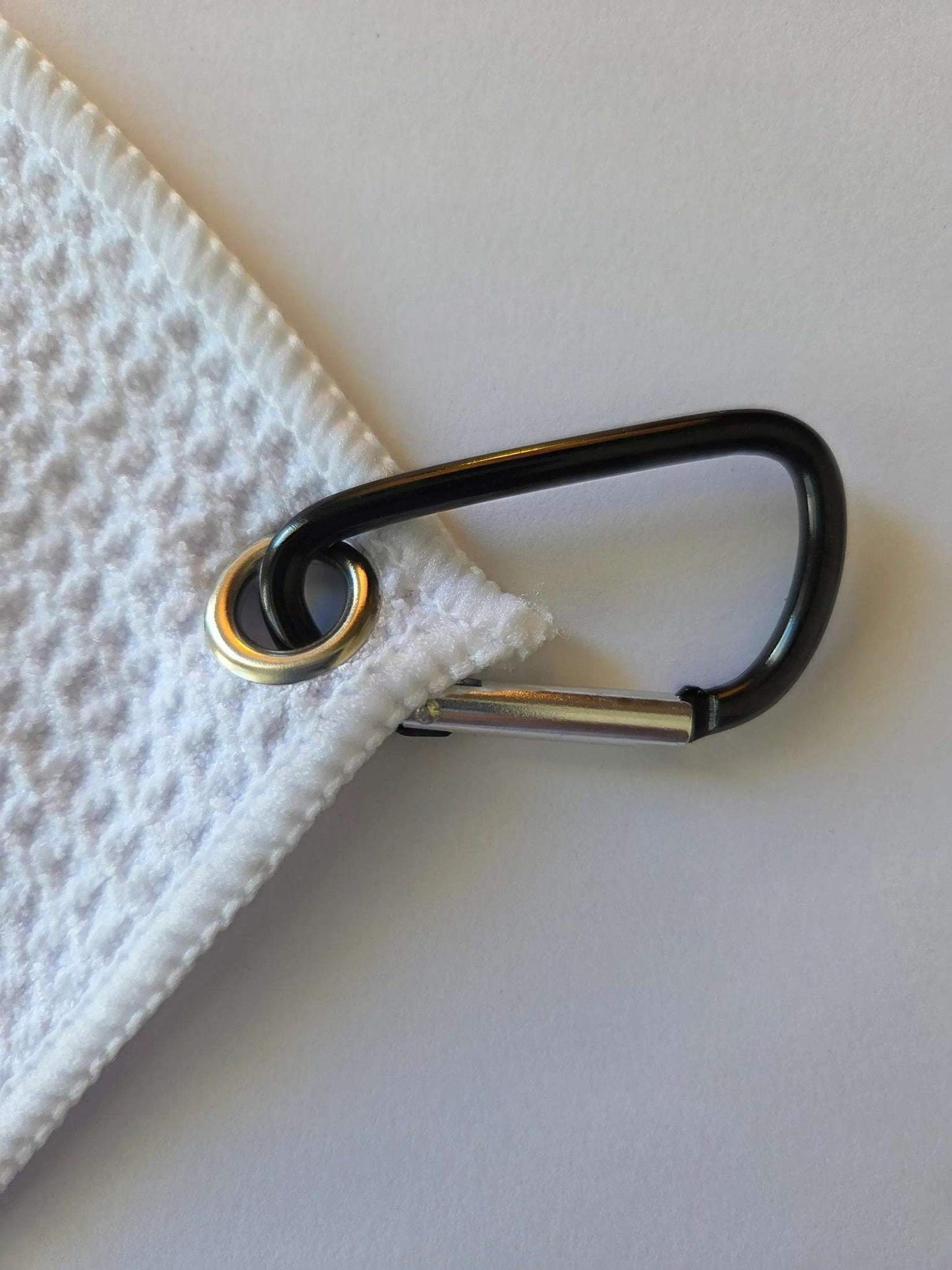 Black carabiner attached to a white textured surface