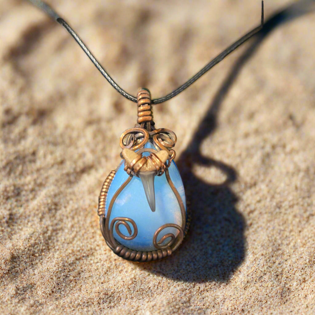Necklace with a blue pendant in a brown box on a textured surface