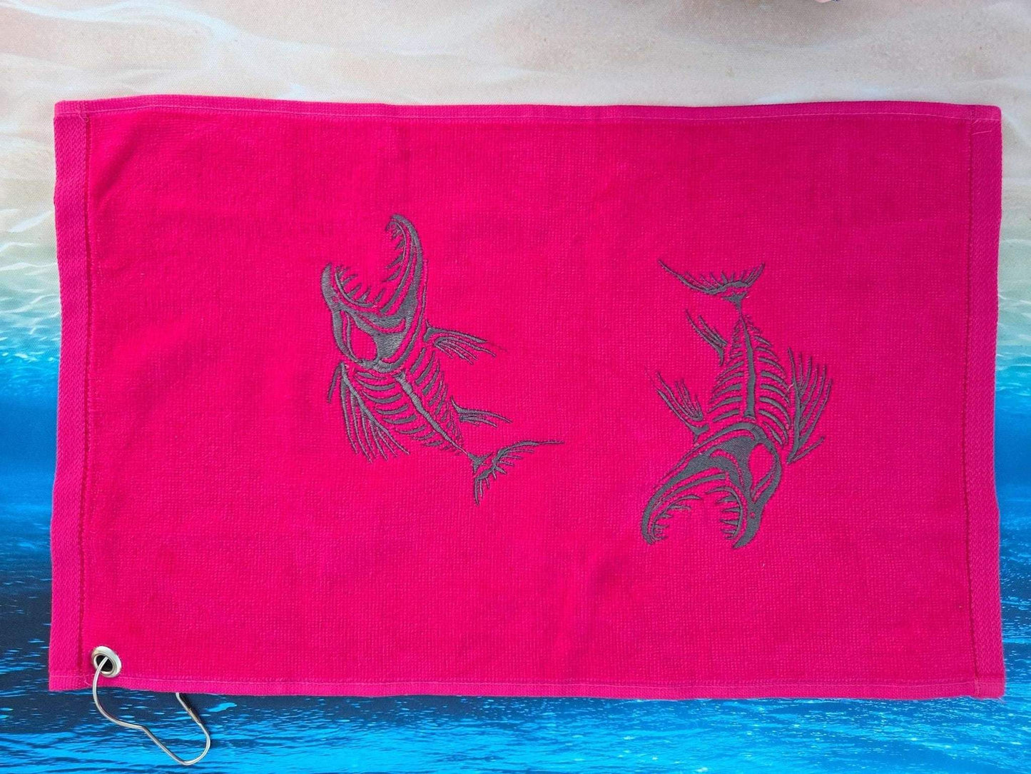 Red towel with black fish designs on a blue and beige background
