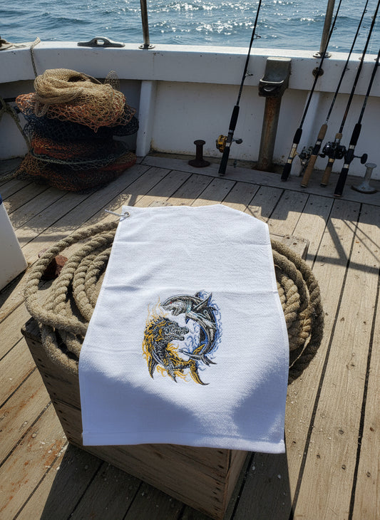 White towel with embroidered design of dolphins on a blue surface